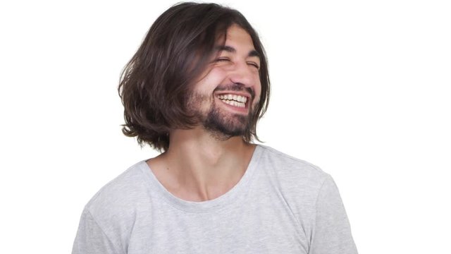 Cool Caucasian guy smiling and making face isolated over white background in slowmotion. Concept of emotions