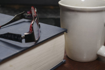 eyeglasses with a book and coffee mug