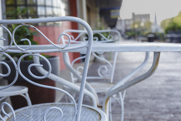 white metal table and chairs outside a shop on a city sidewalk