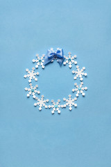 Christmas wreath / Creative concept photo of christmas wreath made of paper snowflakes on blue...