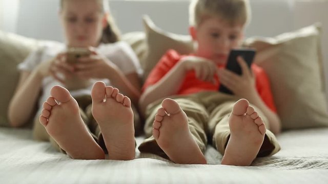 Boy and girl using app on smart phone. 