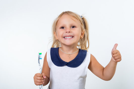 Little girl posing with a toothbrush.. Oral dental health, disease prevention. Positive face expression, emotion