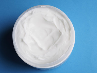 Fototapeta na wymiar Cosmetic cream on blue background