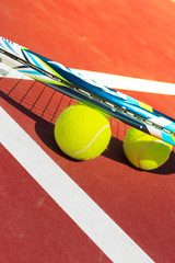 Tennis balls and racket on the grass court