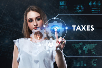 The concept of business, technology, the Internet and the network. A young entrepreneur working on a virtual screen of the future and sees the inscription: Taxes