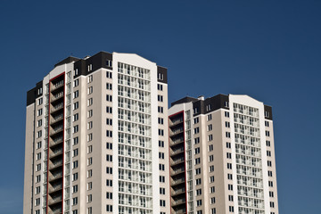 Fototapeta na wymiar Two residential buildings in front of blue sky.