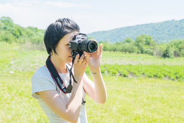 girl on nature with a camera