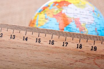 Globe placed beside a wooden ruler