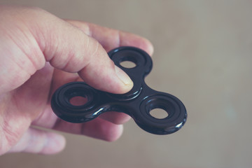 Hand holding fidget spinner toy