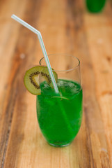 a glass of cold fresh green drink on the wooden bar,