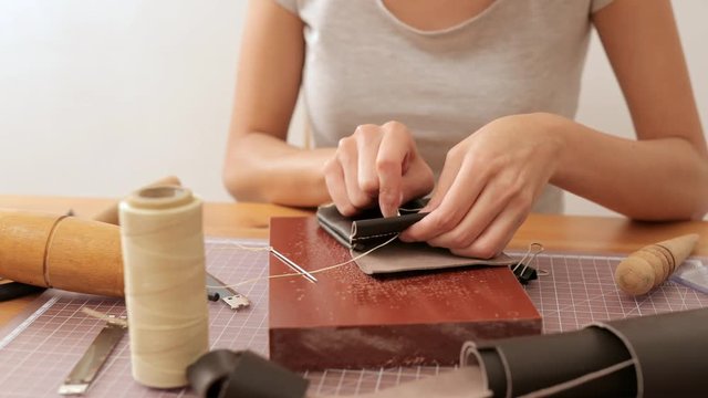 Woman making leather bag