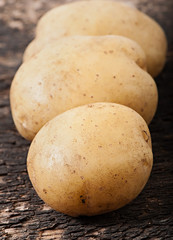 Potatoes on an old wooden background, vegetables.