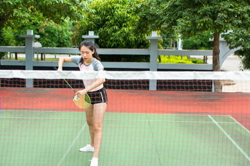 Girl serving on a badminton match outdoors