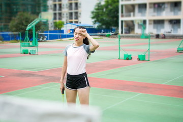 Fototapeta na wymiar Badminton player wiping sweat on the court