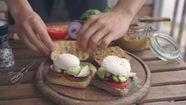 a man making sandwiches with poached egg