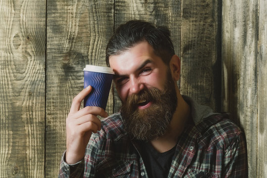 Happy brutal man smiling with blue plastic cup