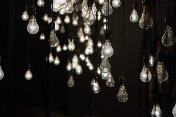 Hanging tungsten lamp bulbs, abstract view, black and white. Part of an art installation at Kochi biennale, Kerala, India