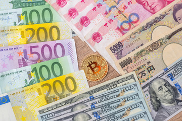 yen, yuan, euro and dollar banknotes with bitcoin