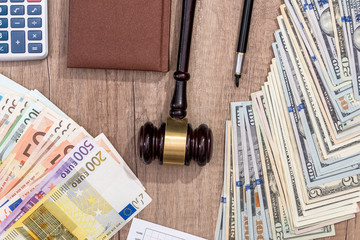 gavel, dollar, euro, notebook, pen on desk