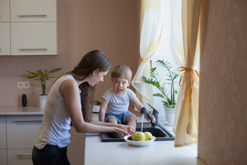 kitchen mom son wash fruits and vegetables