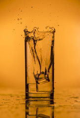 Splash of falling ice in a glass with water