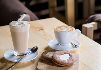cup of coffee and biscuits on a table in a coffee house
