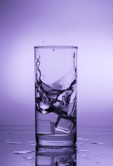 Splash of falling ice in a glass with water