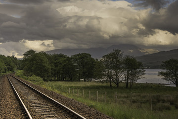 Railway Track Through Woods with Distant Mountains 