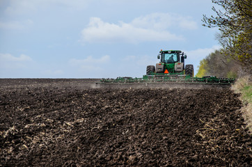 Fototapeta premium Tractor cultivating field