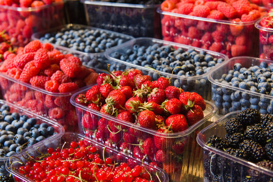 Trays of fresh berries on display at local market.