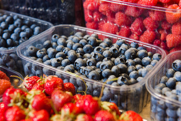 Fresh berries on display. Organic and fresh. Food background. Display on local farmers market. Blueberries close-up
