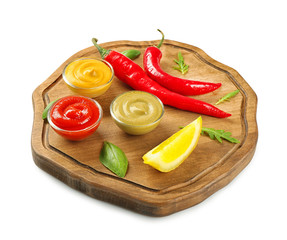 Wooden plate with different sauces, chili and lemon slice on white background