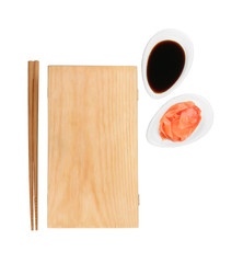 Wooden board, chopsticks, soy sauce and pickled ginger on white background