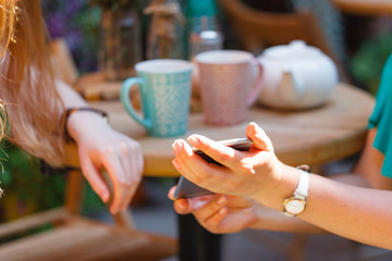 Two cheerful women having friendly chat in cafe