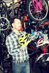 Fototapeta na wymiar Man selects a good helmet for cycling