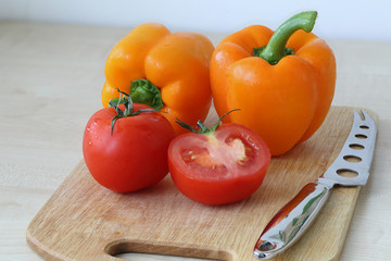 Tomatoes, pepper, knife on the board 