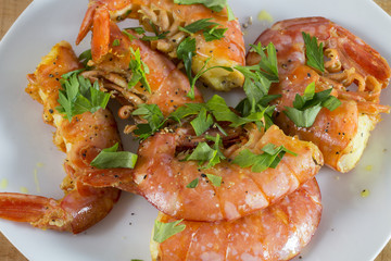 A white dish of king prawns.