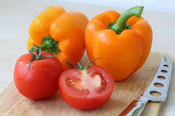 Tomatoes, pepper, knife on the board