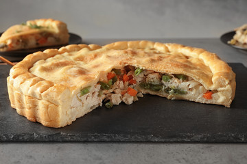 Slate plate with tasty turkey pot pie on gray table