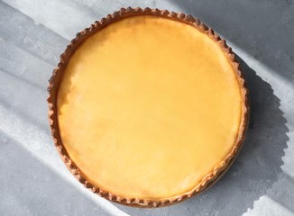Wooden plate with tasty lemon curd pie on table