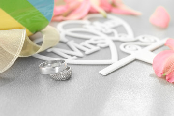Beautiful composition with rings for lesbian wedding on gray background