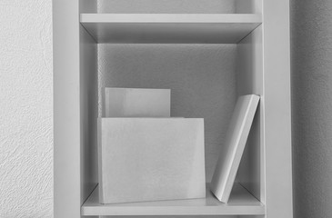 Books with blank white covers on shelf