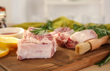 Raw ribs with rosemary on wooden board