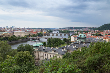 Bridges over Vltava River, Straka Academy and other buildings in Prague, Czech Republic, viewed slightly from above in the daytime.