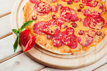 Meat Pizza with tomatoes on the wooden background