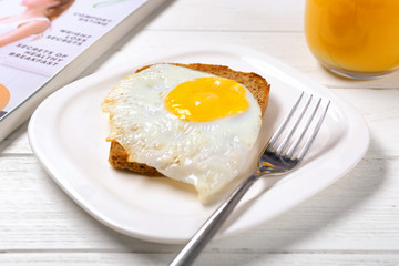 Delicious over easy egg with bread slice on kitchen table