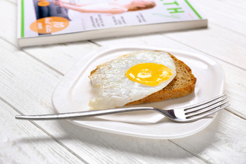 Delicious over easy egg with bread on kitchen table