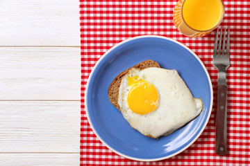 Delicious over easy egg with bread and orange juice on kitchen table