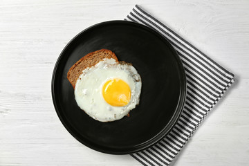 Delicious over easy egg with bread on kitchen table