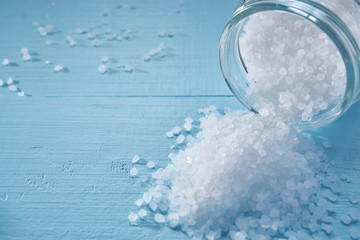 closeup of a small sea salt pile spilled from jar - obrazy, fototapety, plakaty